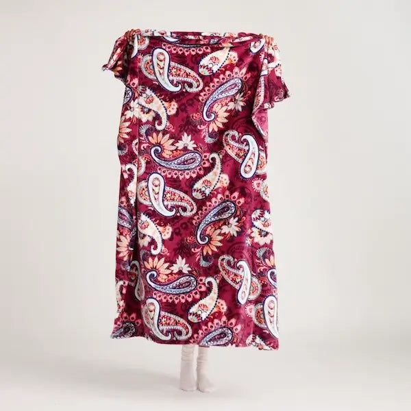 Model holding up Vera Bradley paisley fleece throw blanket